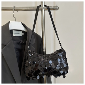 Close-up of black sequined underarm bag with reflective scales and leather strap