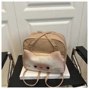 Close-up of beige kitten-themed crossbody bag with cat face pocket on white background