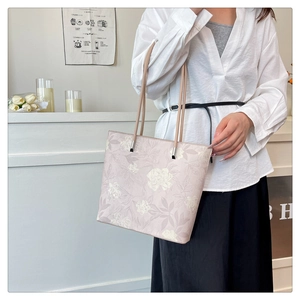 Detailed shot of large capacity tote bag featuring purple floral pattern and thin straps