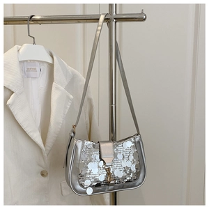 Détail du sac à bandoulière à paillettes argentées avec fermoir métallique chic
