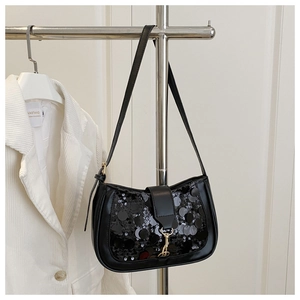 Gros plan du sac baguette à paillettes noires avec boucle métallique dorée élégante