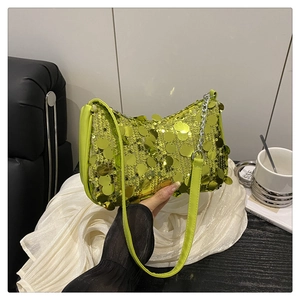 Detail of neon green sequin baguette bag with silver chain and leather strap accessory
