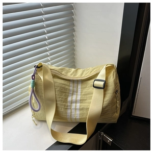 Detail of light yellow striped yoga gym bag with an adjustable strap and knot charm