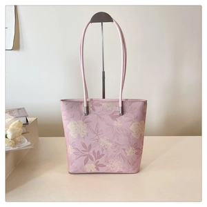Detailed close-up of pink floral tote bag with vintage flower patterns and metal hardware