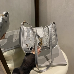 Sac baguette à paillettes argentées avec chaîne en métal et reflet dans le miroir