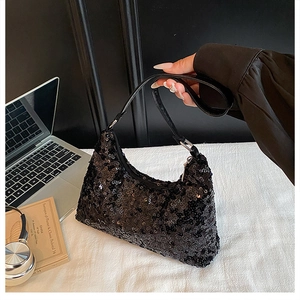 Detail of a sparkling black sequin hobo bag with a leather strap and metallic buckle