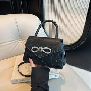 Chic black crocodile pattern handbag with a sparkling silver rhinestone bow detail