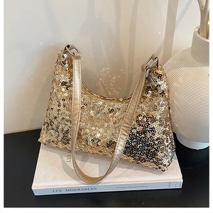 Detail of gold sequined hobo bag resting on a book showing luxury texture and finish
