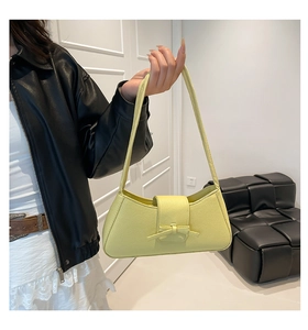 Detalle del bolso de hombro amarillo en cuero granulado con un elegante lazo