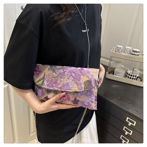 Detail of purple sequin floral embroidery and gold chain strap on the envelope clutch