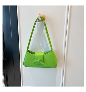 Detalle del bolso de hombro verde lima en cuero granulado con un elegante lazo frontal