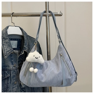 Detail of light blue pleated shoulder bag with fringe tassel and fluffy cloud charm