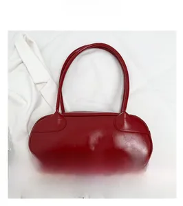 Flat lay of a red minimalist PU leather baguette bag on a textured white fabric background