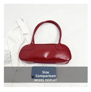 Size comparison of red glossy baguette bag with a smartphone for scale reference