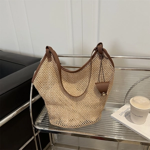 Large woven tote bag in light brown with leather straps and a matching small pouch
