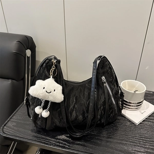 Fashionable black textured handbag with plush cloud charm and stylish front zipper pocket