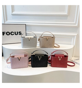 Close-up of glitter fabric handbags with V-shaped metal buckles in five colors