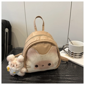Détail du mini sac à dos chat beige avec un charmant porte-clés ours en peluche