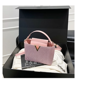 Sac à main rose scintillant avec logo V doré présenté dans une boîte cadeau noire