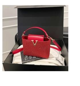 Vue détaillée du sac à main rouge à paillettes avec fermoir en V doré en boîte cadeau