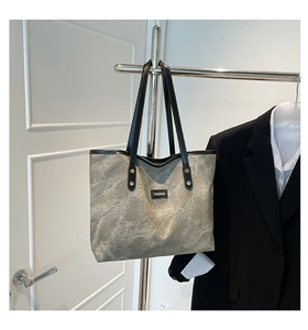 Dettaglio borsa shopper in tela marmorizzata grigia con finiture in pelle nera