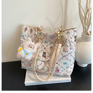 Detail of cartoon tote bag with pearl chain, teddy bear print and plush charm