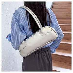 Detail of silver metallic leather shoulder bag showing smooth texture and curved stitching