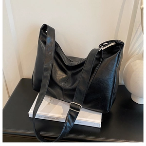 Détail macro du sac cabas en cuir noir texturé avec boucle argentée réglable