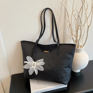 Sac fourre-tout noir minimaliste avec texture froissée et pendentif fleur blanche
