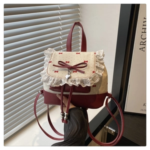 Detail of red and white ballet-style backpack with lace trim and bow decorations