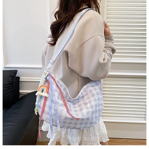 Detail of light blue plaid crossbody bag with cute bear embroidery and plush charm