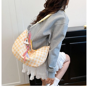 Detail of yellow plaid hobo bag featuring rainbow pendant and cute bear embroidery