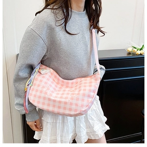 Detail of pink plaid crossbody bag featuring cute rabbit and heart embroidery on fabric