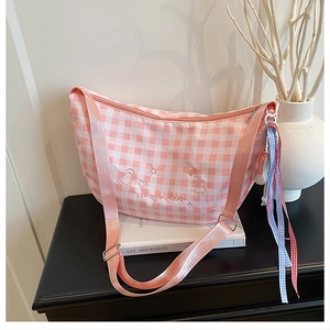 Close-up of pink checkered canvas bag featuring bear embroidery and ribbon detail