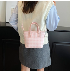 Detail view of mini pink plaid tote bag with silver rivets and adjustable shoulder strap
