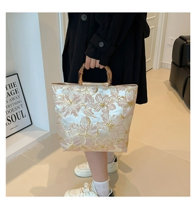 Close-up of retro bamboo handles and intricate floral jacquard fabric on a tote bag