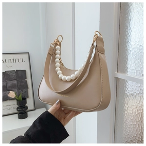Dettaglio borsa a tracolla in pelle PU beige con catena di perle e scritte dorate