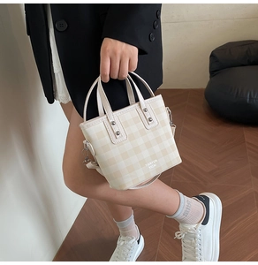 Detail of checkered bucket bag featuring silver rivets and TIANYUN YICAI logo print