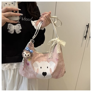 Pink velvet shoulder bag detail featuring dog embroidery, lace bow, and plush bear charm
