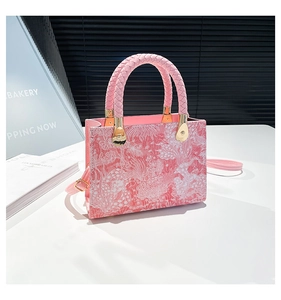 Dettaglio borsa a mano rosa a fiori con manico intrecciato e metallo dorato