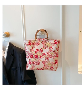 Detail of red and gold floral embroidery on silk tote with retro bamboo handle