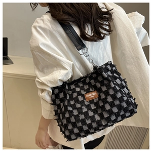 Detail der karierten Denim-Tasche mit Fransen und silberner Kette für Damen