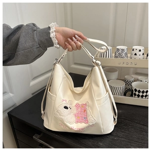 Detail of cream multi-pocket handbag with cute puppy embroidery and Happy Puppy text