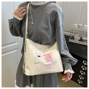 Detail of off-white PU tote bag featuring a cute white puppy embroidery and pink text