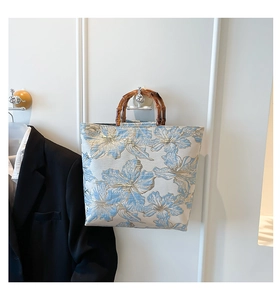 Detail of floral jacquard fabric texture and natural bamboo handle on tote bag