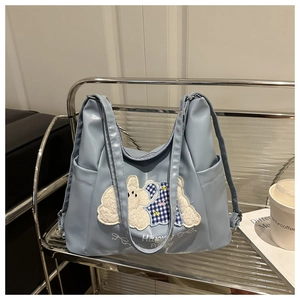 Detail of light blue tote bag with plush puppy embroidery and Happy Puppy lettering