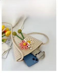 Detailansicht der Kapazität einer Strohtasche mit Smartphone und kleinem Klappschirm