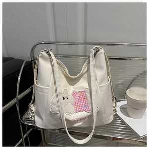 Detail of white tote bag featuring cartoon puppy towel embroidery and Happy Puppy text