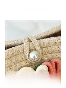 Detailansicht der handgewebten Tasche mit Perlenknopf und floralen Knotendekorationen
