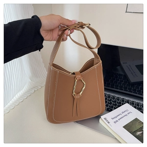 Detailed view of caramel PU leather bucket bag with contrast stitching and gold buckle